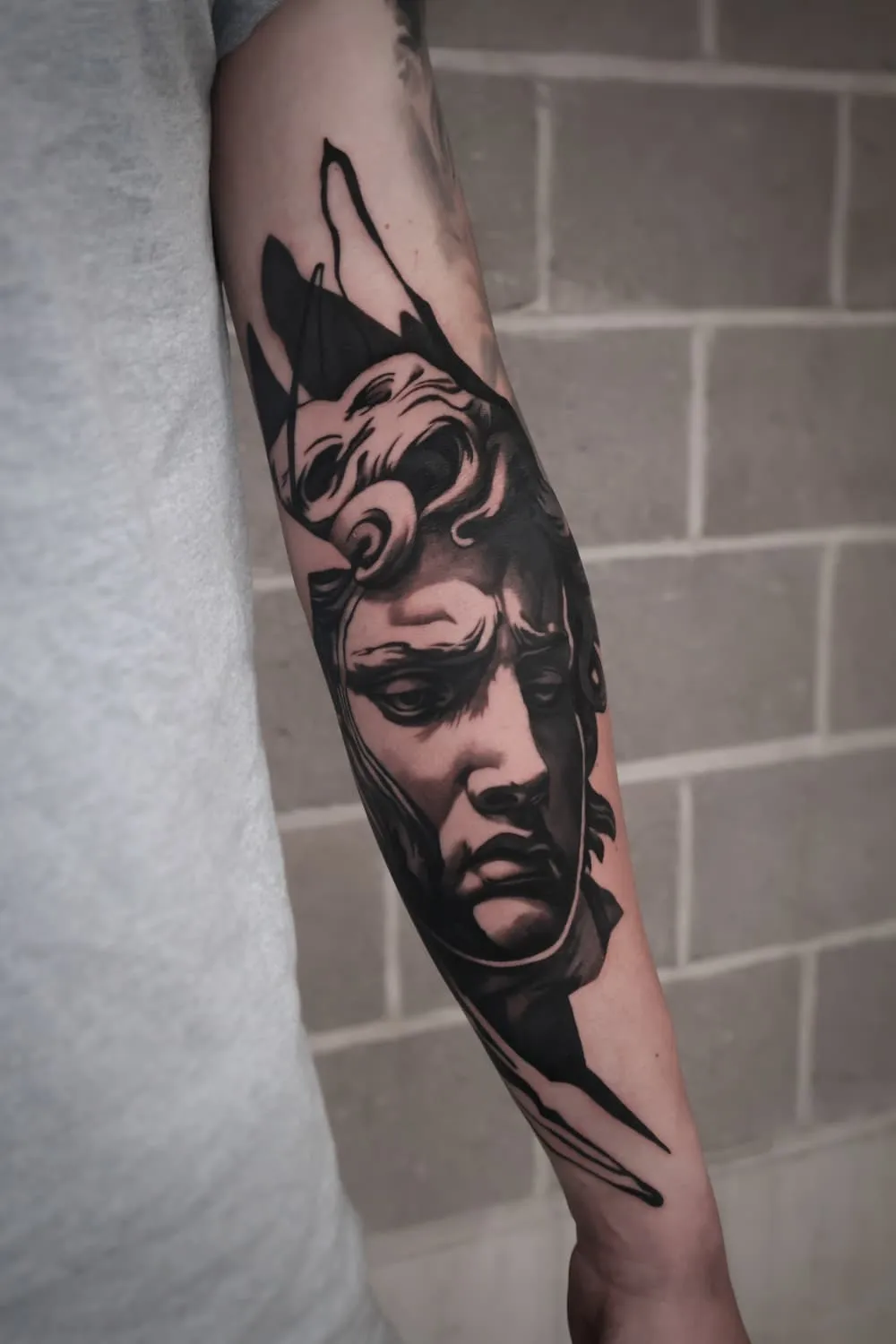 Statue: black and grey tattoo on the forearm