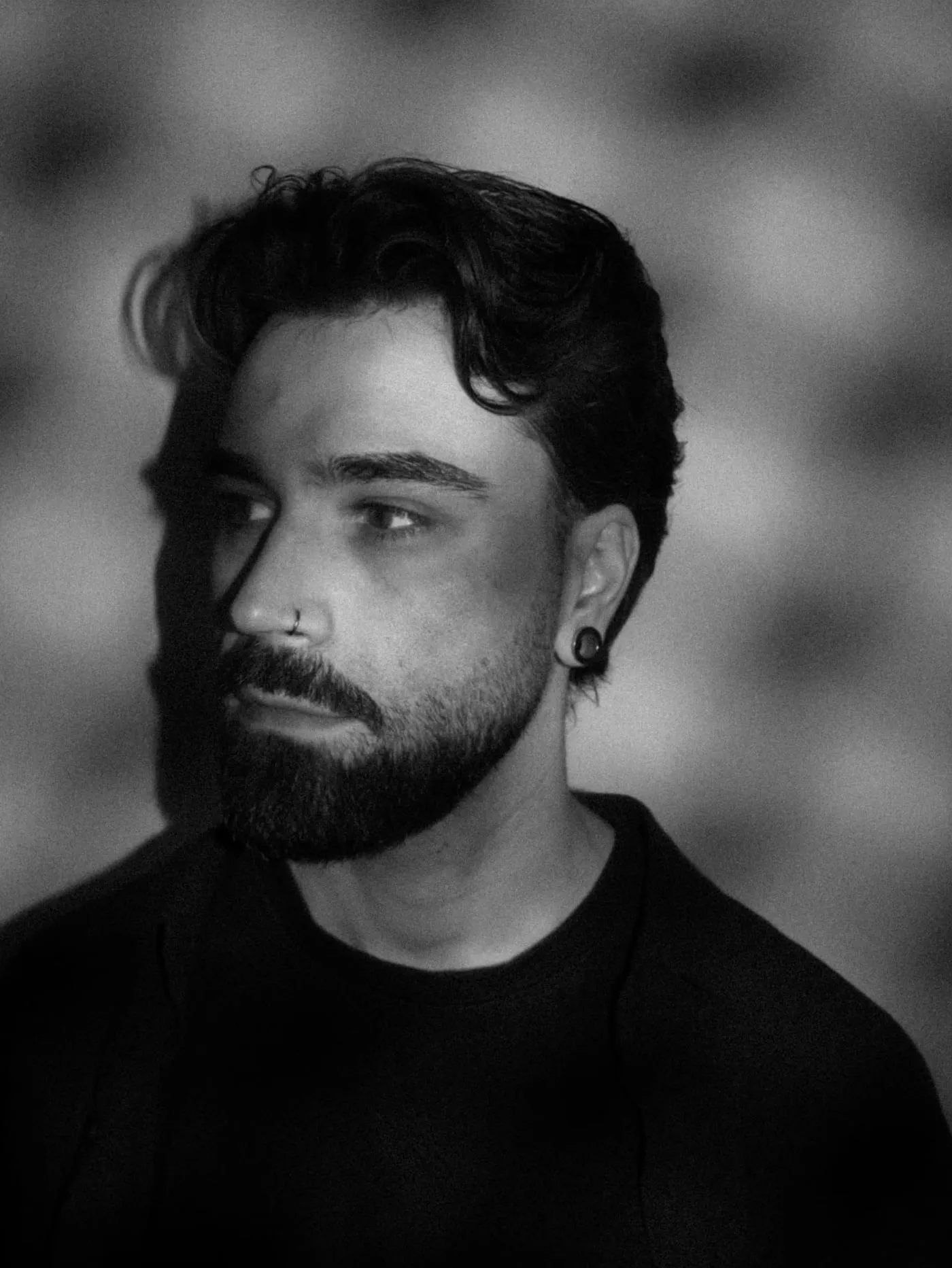 Black and white portrait of Chesney Foss, looking to the side in dramatic light